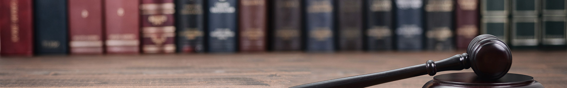 legal books on a shelf with judges gavel in front of them