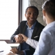 Two businessmen, one black and one white, shaking hands